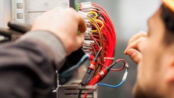 Ein Elektroniker der an einem Verteilerkasten arbeitet